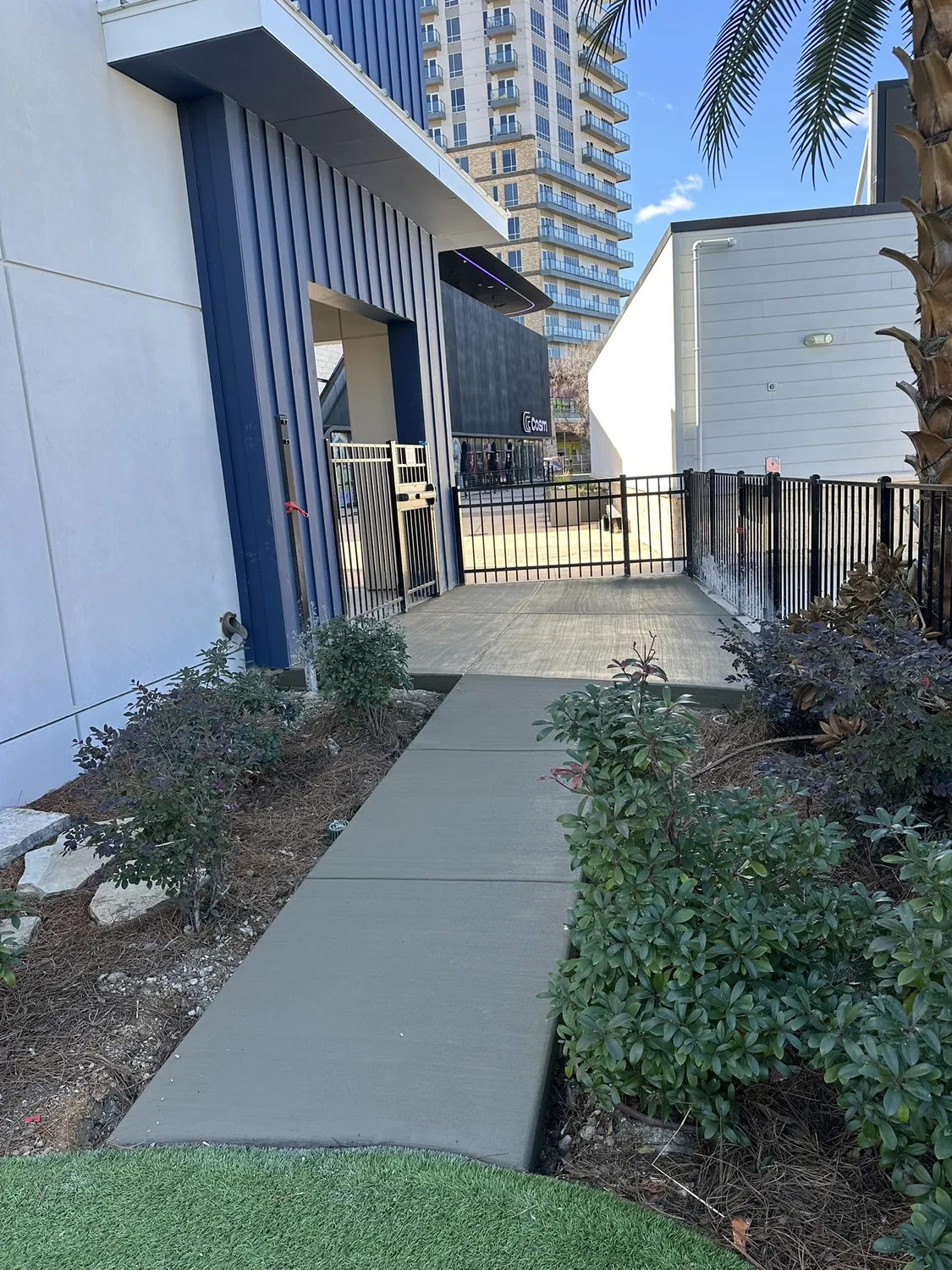 New commercial concrete sidewalk running alongside a building by Billy's Concrete