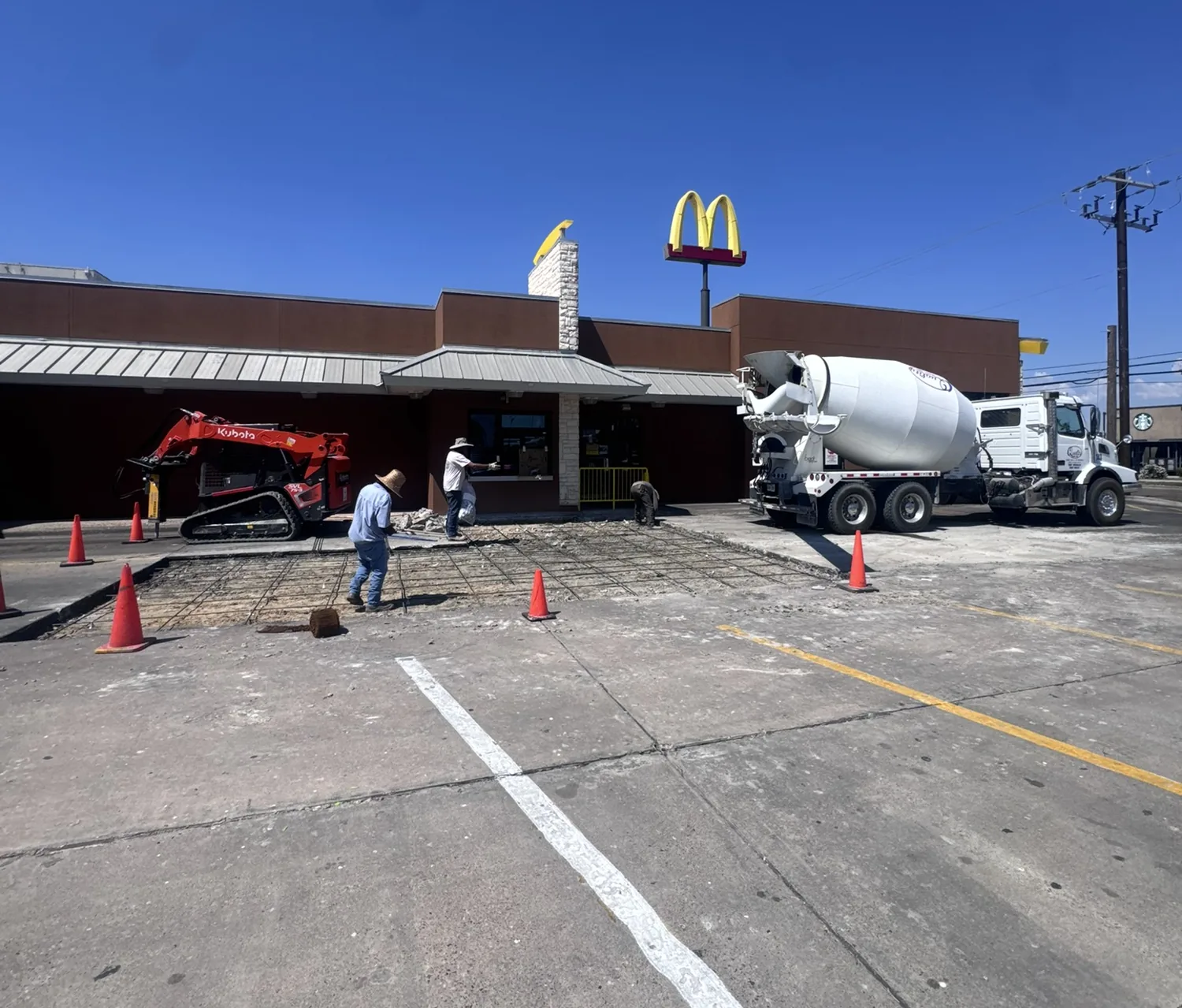 Billy's Concrete crew pouring a commercial parking lot at a McDonald's with rebar grid and a concrete mixer truck on site